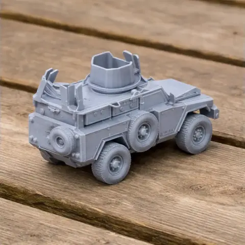 Gray 3D-printed model of a six-wheeled military armored vehicle with a turret on wooden surface.