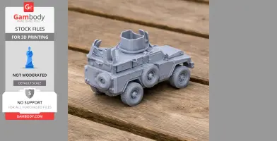 Gray 3D-printed model of a Mamba APC tank on a wooden surface, showcasing wheels and turret detail.