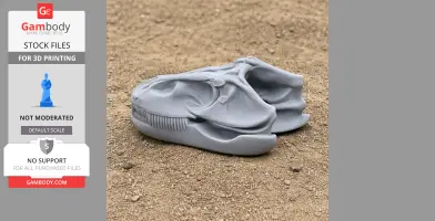 Gray 3D-printed Theiophytalia dinosaur skull replica on a sandy surface.