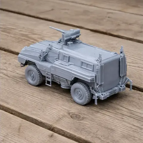 3D-printed model of a mine-protected vehicle with a turret, shown on a wooden surface.