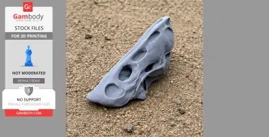 A gray 3D printed Therapsida skull replica is resting on sandy ground.