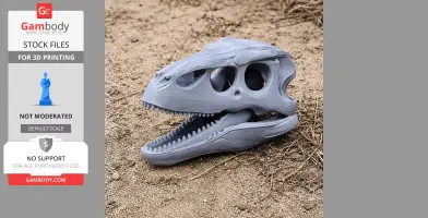 A 3D-printed Therizinosaurus skull replica lying on sandy ground.