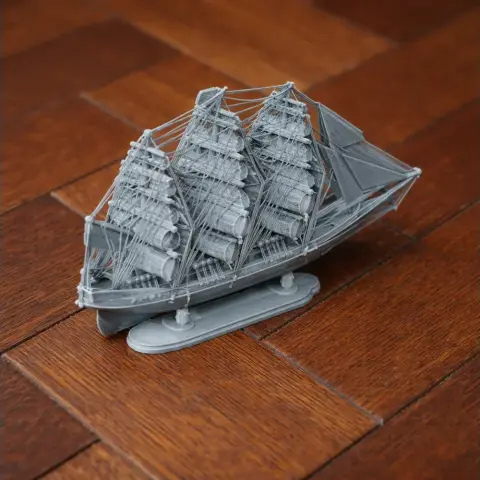 Detailed 3D-printed model of the Cutty Sark clipper ship on a wooden surface.