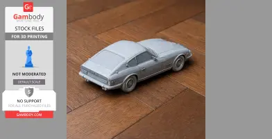 3D-printed model of a Datsun Sports car in gray on a wooden surface.