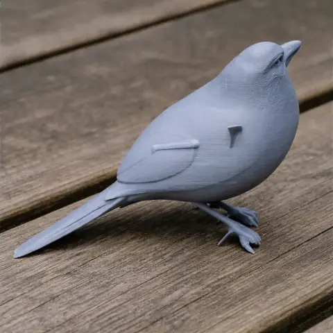 3D printed model of a small bird standing on a wooden surface.