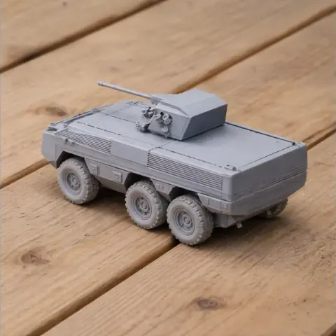 Gray 3D-printed model of a six-wheeled armored vehicle with a turret on a wooden surface.
