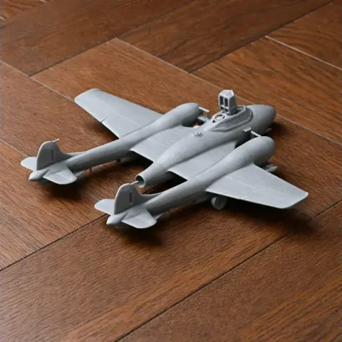 3D printed model of a De Havilland Sea Venom plane on a wooden surface.