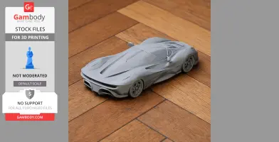 Gray 3D-printed model of a De Tomaso sports car on a wooden floor.