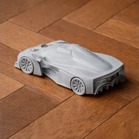 3D printed model of a sleek, futuristic car on a wooden surface.