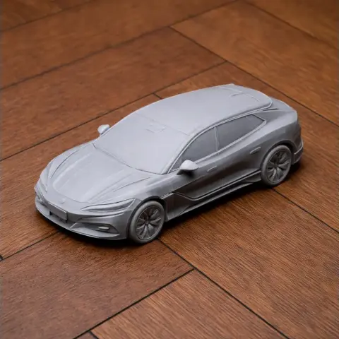 3D printed model of a sleek, modern car placed on a wooden surface.