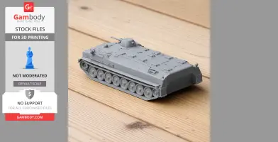 3D printed MT-LB tank model in gray, displayed on a wooden surface.