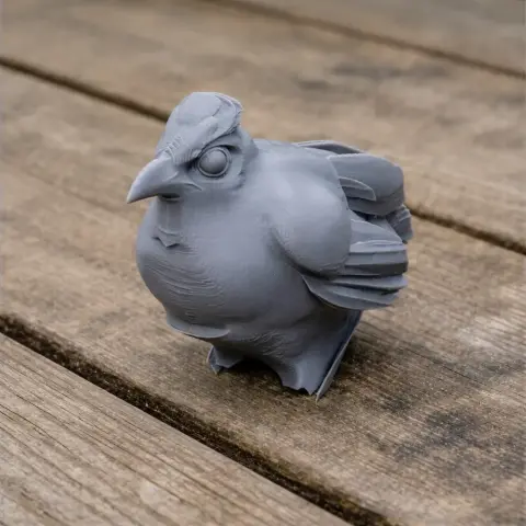 Gray 3D-printed model of a banded ground cuckoo with detailed texture on a wooden surface.