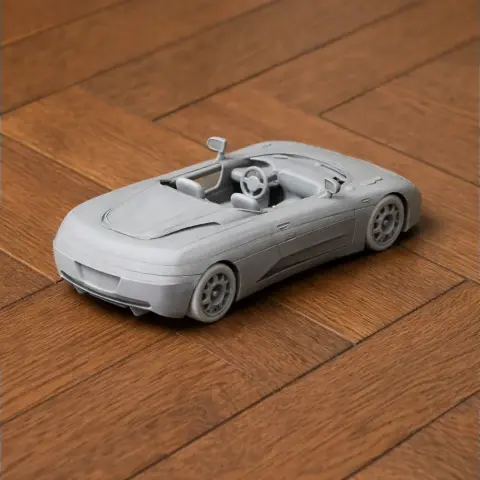 3D-printed model of a De Tomaso Guara car, featuring detailed exterior and interior, on a wooden surface.