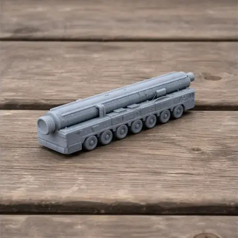 A detailed 3D-printed model of a missile carrier vehicle with multiple wheels on a wooden surface.