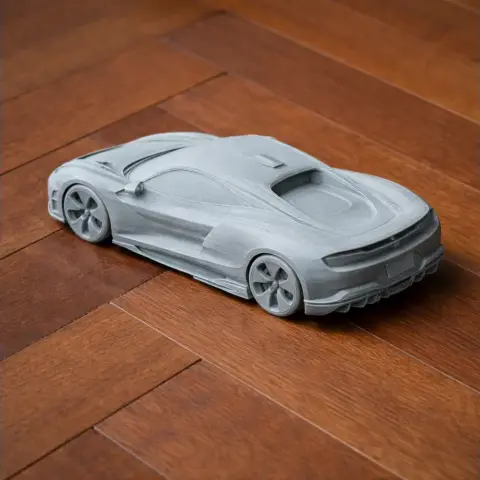 3D-printed scale model of a sleek sportscar on a wooden surface.