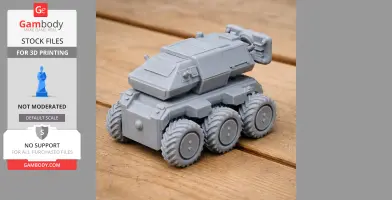 A six-wheeled, gray 3D-printed tank model with an angular body on a wooden surface.
