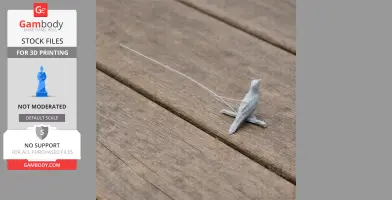 A small, gray 3D-printed bird model on a wooden surface.