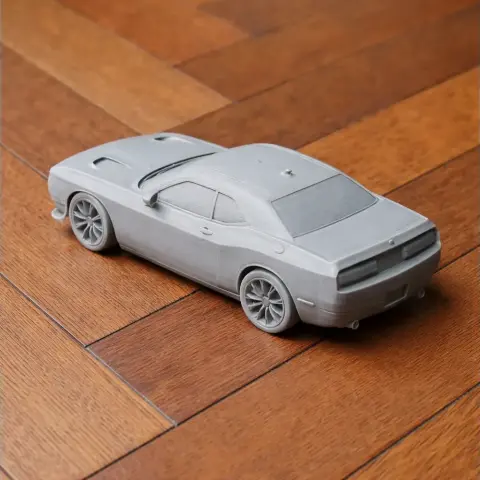 Gray 3D-printed model of a Dodge Challenger on a wooden surface, viewed from the rear.