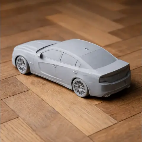 Gray 3D-printed model of a Dodge Charger car on a wooden floor.