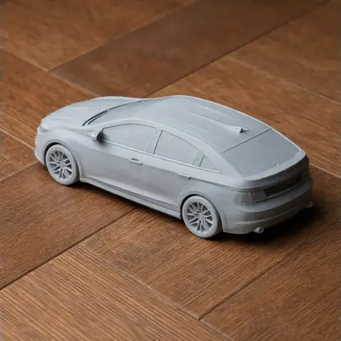 3D-printed Dodge Dart model on a wooden surface, viewed from the rear side.
