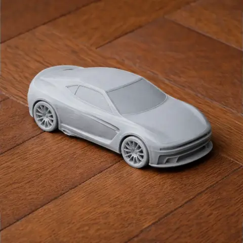 3D-printed model of a sleek, futuristic sports car on a wooden surface.