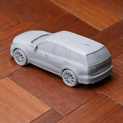 3D printed model of a Dodge Durango on a wooden surface, showcasing detailed wheels and bodywork.