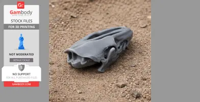 A 3D printed Uteodon skull replica in gray, lying on sandy ground.