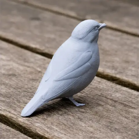 3D-printed model of a bird with detailed feathers, perched on a wooden surface.