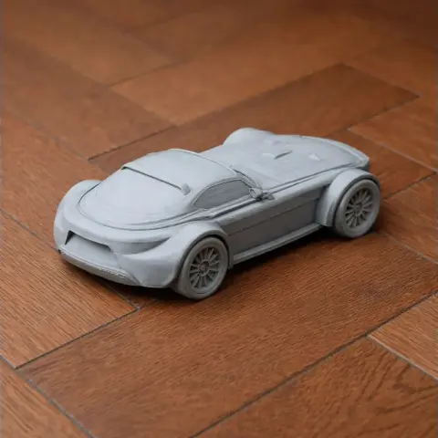 3D-printed scale model of a sleek car on a wooden surface.