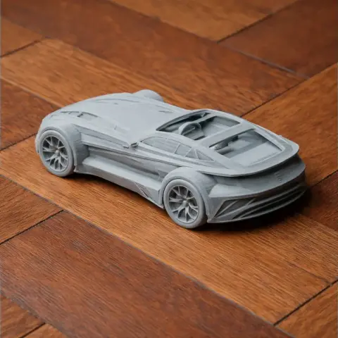 3D-printed model of a sleek sports car, resembling a Donkervoort F22, on a wooden surface.