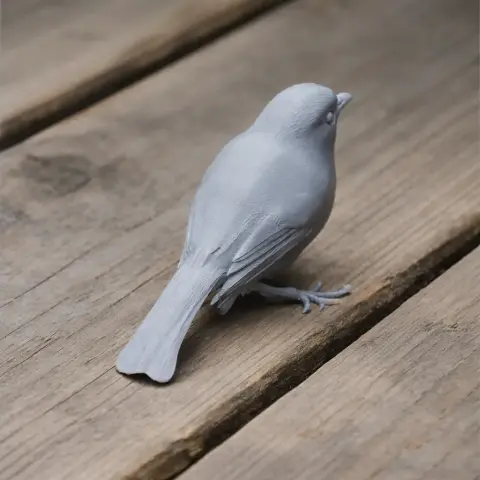 Gray 3D-printed bird model with detailed feathers, perched on a wooden surface.