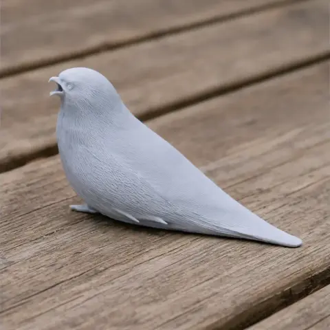 A 3D-printed model of a prehistoric bird, resembling a wren, perched on a wooden surface.
