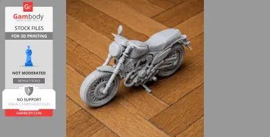 3D-printed Ducati Scrambler model on wooden floor, showcasing intricate motorcycle details.