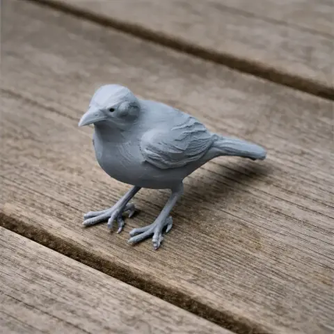 3D printed model of a thrush bird on a wooden surface.