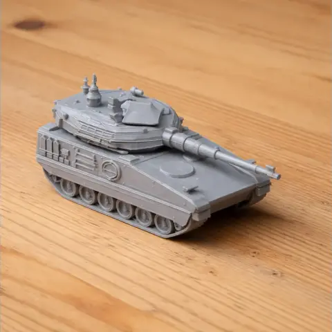 Detailed model of a tank with a long barrel and turret, displayed on a wooden surface.