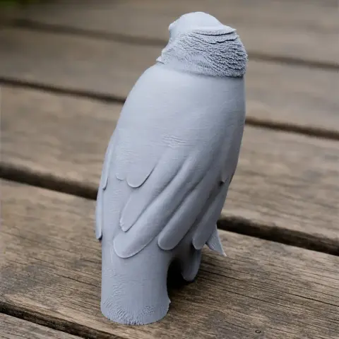 Gray 3D-printed bird figure standing on a wooden surface facing away.