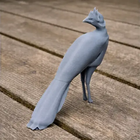 3D printed model of a bare-faced curassow bird, standing on a wooden surface.