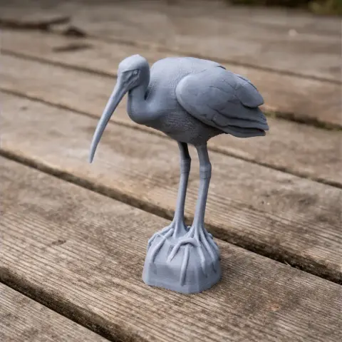 A 3D-printed model of a bare-faced ibis with long legs and a curved beak, standing on a textured base.