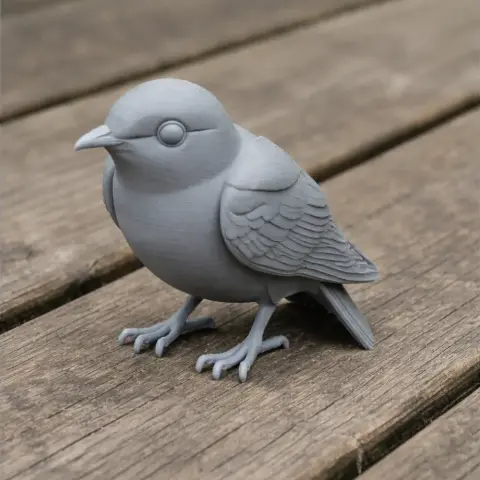 3D printed gray model of a bird with detailed wings, perched on a wooden surface.