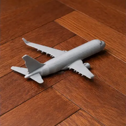 3D printed model of Embraer E190 airplane on wooden surface.