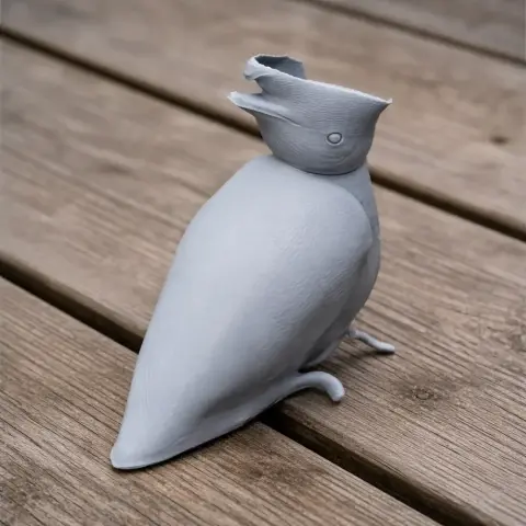 Gray 3D model of a bare-necked umbrellabird with distinctive crest, sitting on wooden surface.