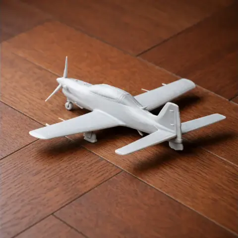 3D printed model of Embraer EMB 312 Tucano aircraft on wooden surface.