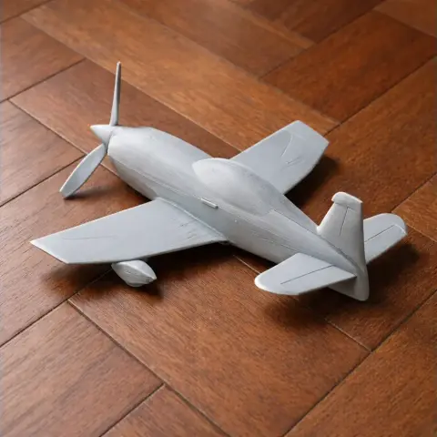 A gray 3D-printed model of an Extra EA-300 plane on a wooden surface.