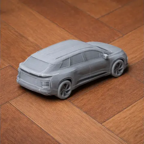 3D-printed model of a Faraday Future FF 91 vehicle on a wooden surface.