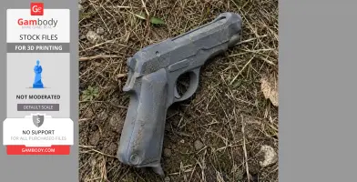A 3D-printed Beretta M1935 replica prop, lying on grass and dirt, showcasing details and texture.