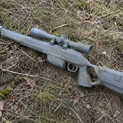 A detailed 3D-printed Blaser R93 Tactical prop resting on grass, featuring a scope and textured body.