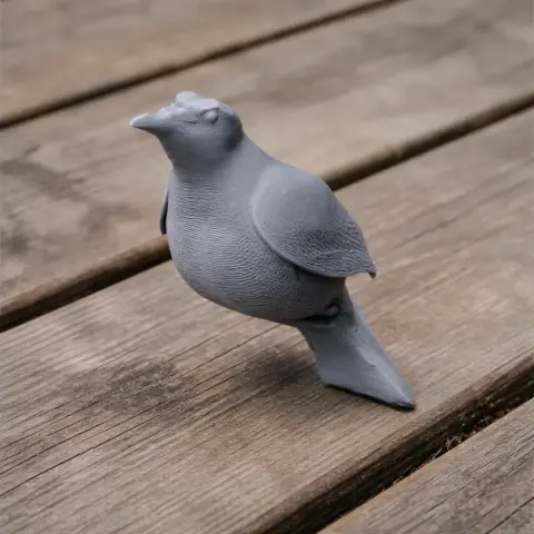 A gray 3D-printed bird model standing on wooden planks.