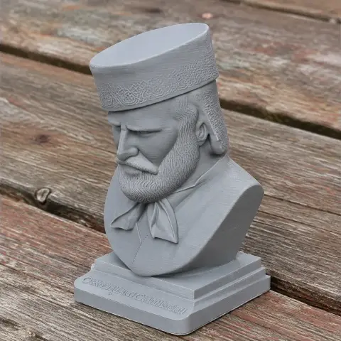 3D-printed bust of a bearded man with a hat, detailed attire on a wooden surface.