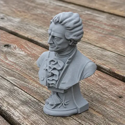 A detailed 3D-printed bust of a historical figure on a wooden surface.