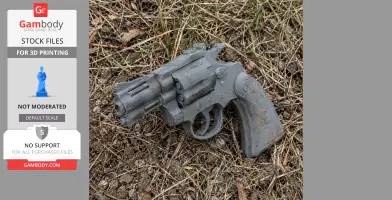 A 3D-printed Colt Diamondback revolver prop lying on dry grass.
